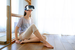Frau mit VR-Brille auf Sofa