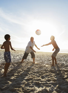 Familie spielt Volleyball am Strand