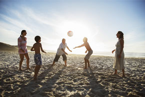 Familie spielt Volleyball am Strand